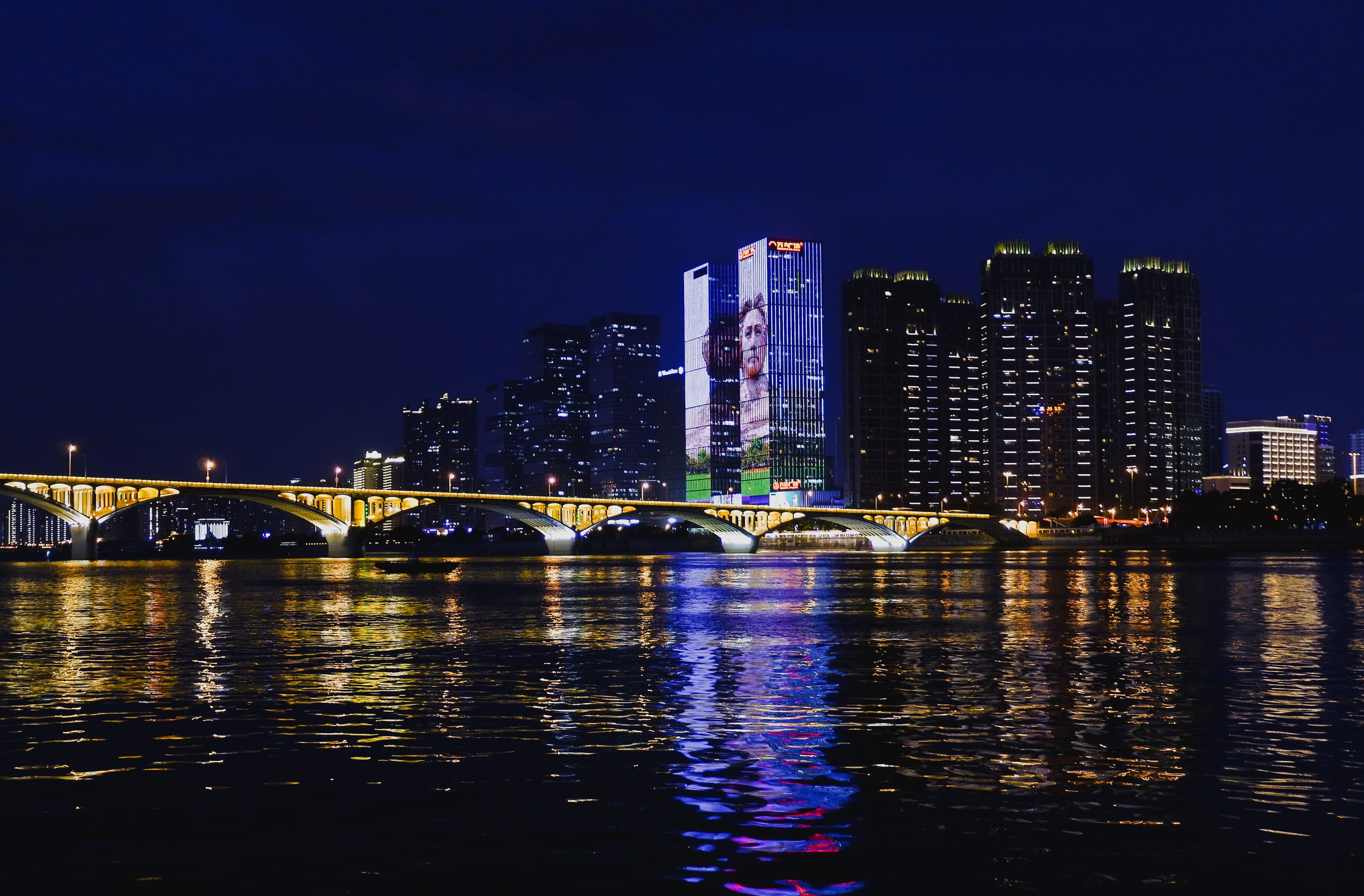 City skyline and bridge reflected in a river at night